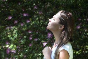 Achtsamkeit. Frau hält das Gesicht in der Natur in die Sonne.