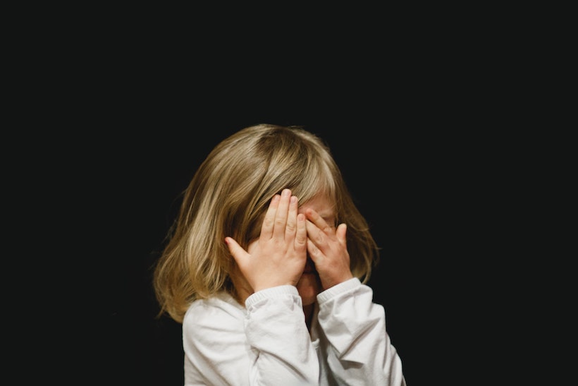 Mädchen hält sich die Augen zu und hat Angst